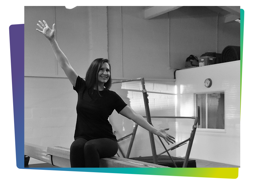 Affinity founder, Jennifer Page, sitting on beam in gym